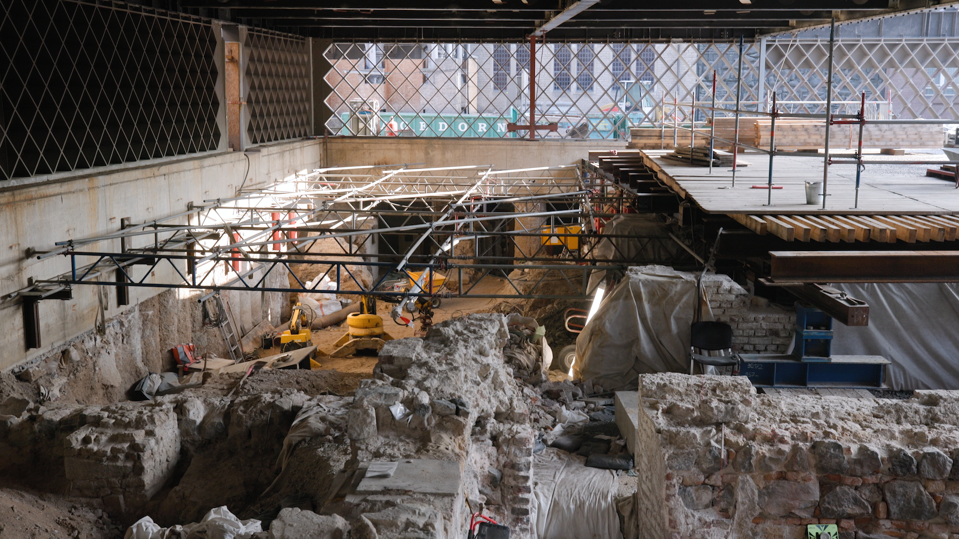 Blick in die Ausgrabung im Untergeschosse mit den Stahlrauten für das Erdgeschoss dahinter und dadurch mit dem Blick auf das Historische Rathaus.