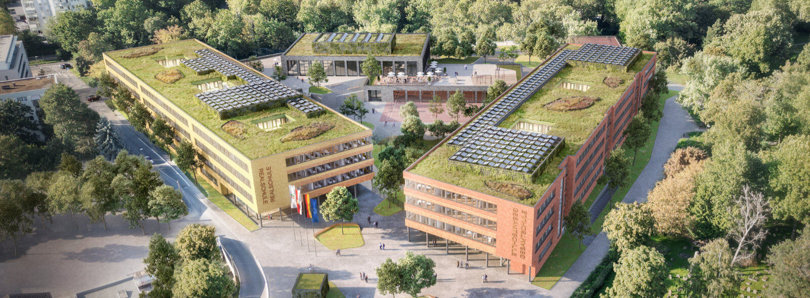 Die Realschule und die Gesamtschule aus der Vogelperspektive: umgeben von vielen Bäume, die Dächern sind begrünt und mit Photovoltaikmodulen bestückt
