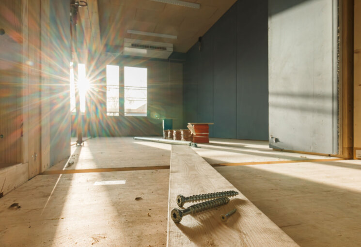 Drei Schrauben auf einer Holzdiele liegend, die in einen künftigen Klassenraum reicht. Durch das Fenster dahinter ist strahl die Sonne herein., © Matthias Meurer / Stadt Köln