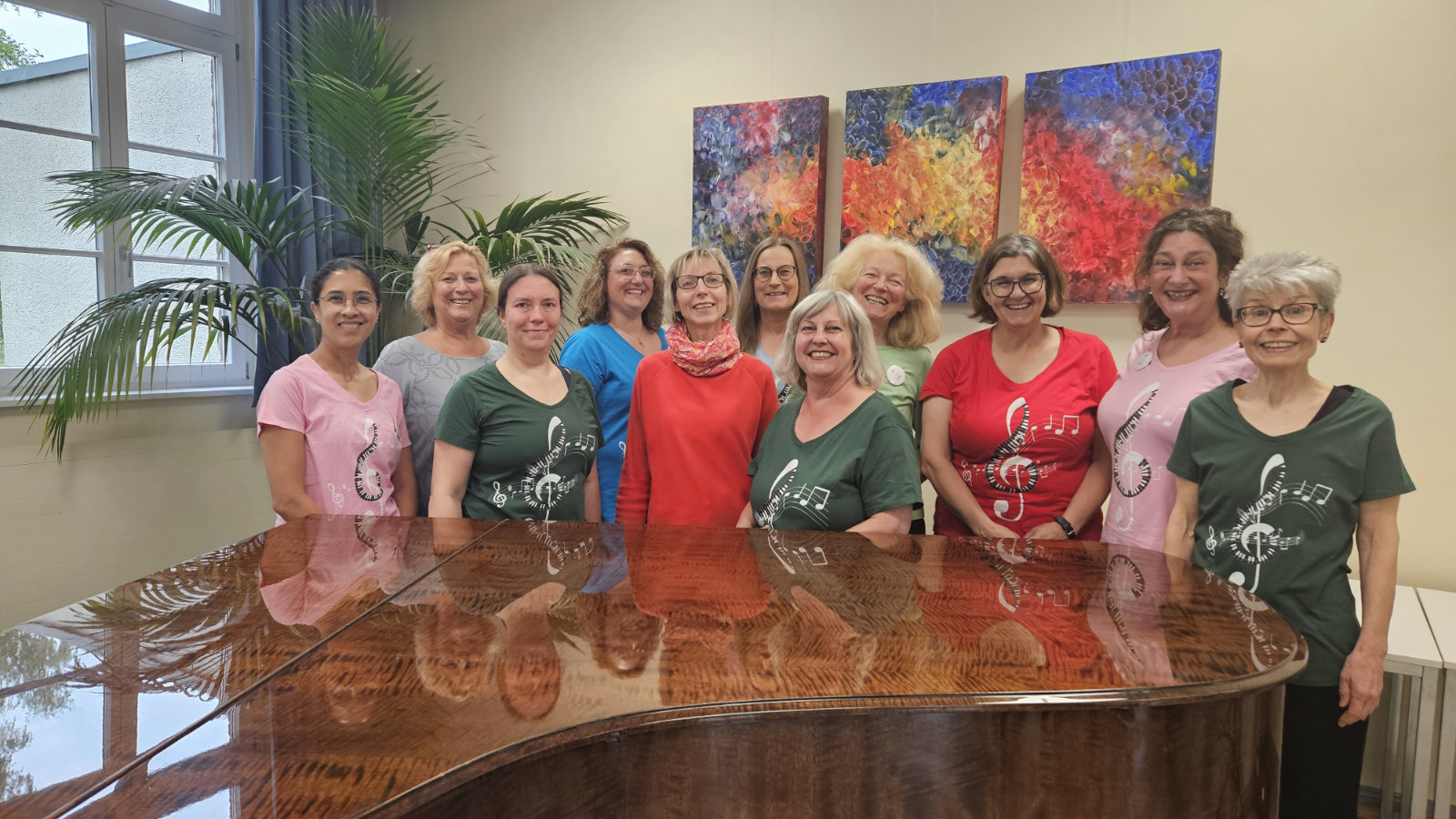 Die Mitglieder des Luzie-Frauenchors stehen hinter einem Flügel im Gerold-Kürten-Saal der Regionalschule Holweide.