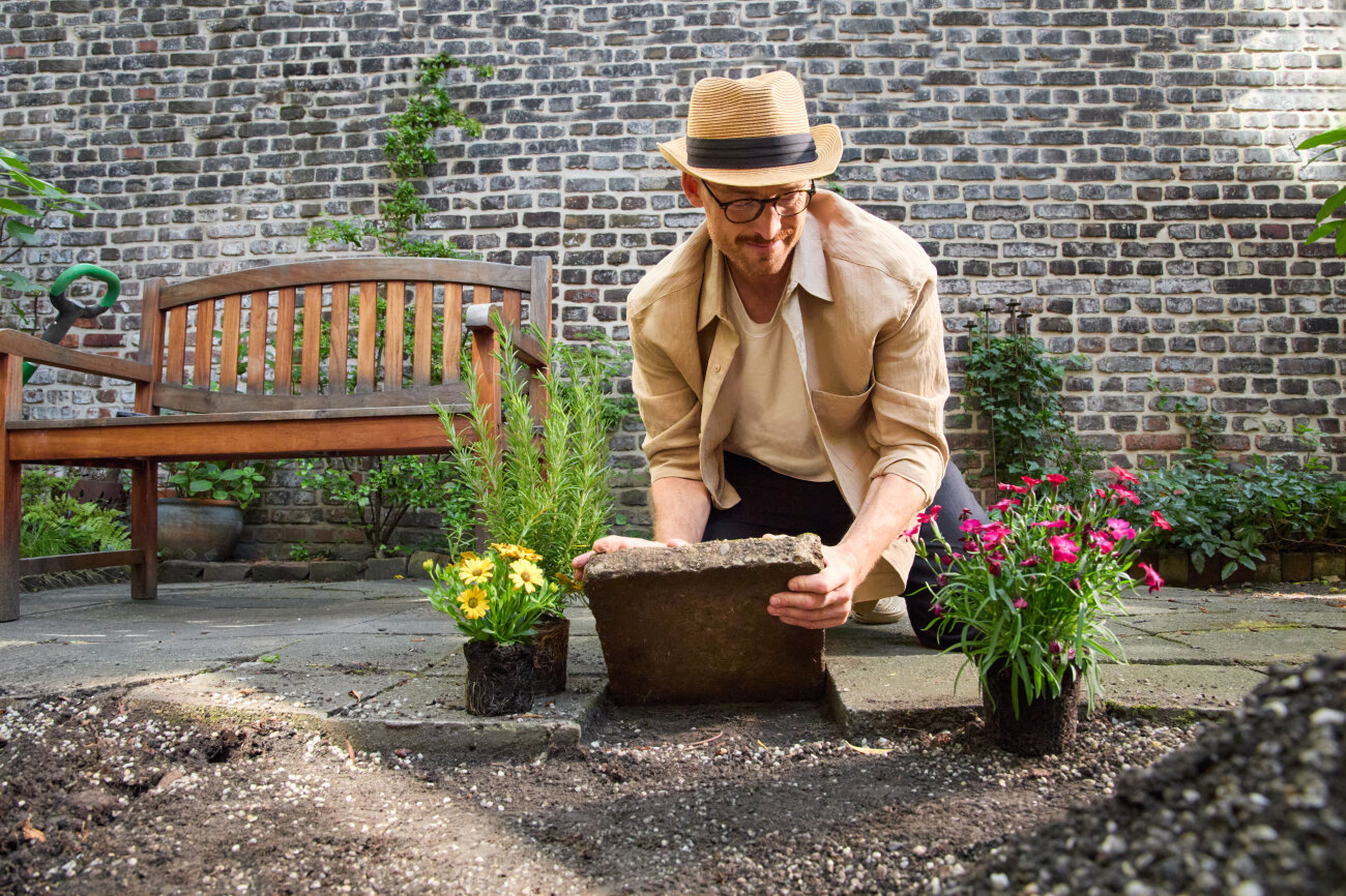 Mann entfernt Pflastersteine