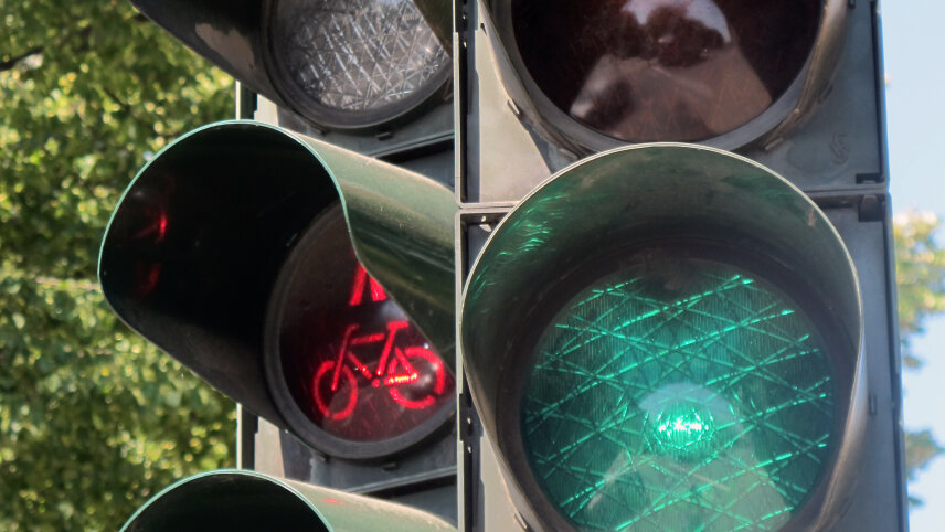 Ampel mit einem grünen Signal für den Fahrzeugverkehr und einem roten Signal für zu Fuß Gehende und Radfahrende